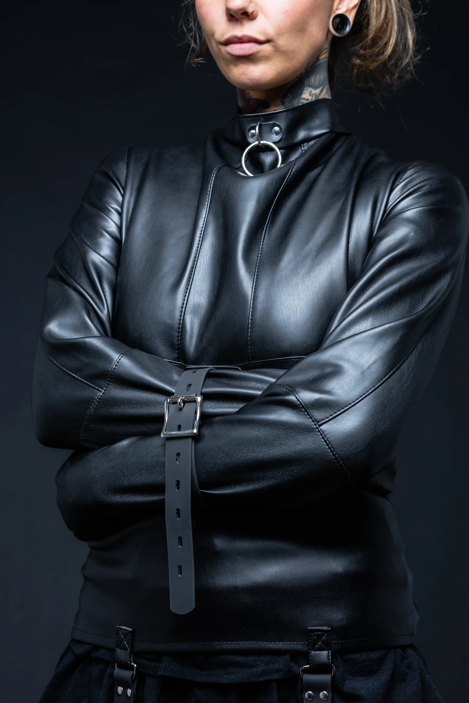 The Asylum Adventurer black synthetic leather straitjacket with sleeves crossed in front.