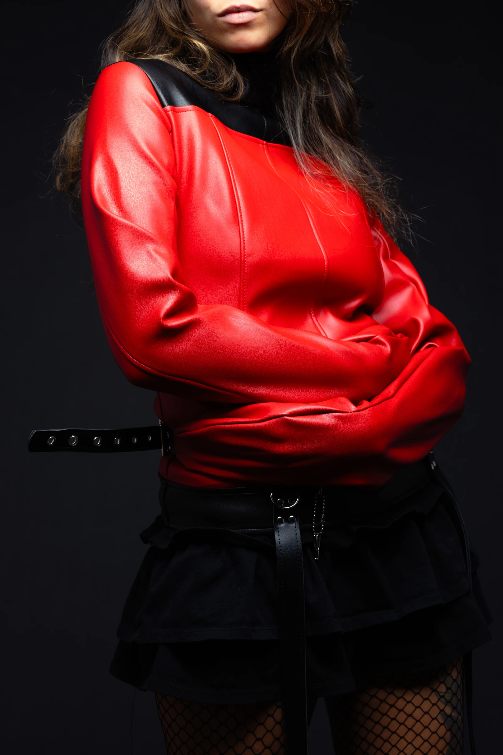 The Experimentalist red-and-black synthetic leather straitjacket with sleeves crossed in front.